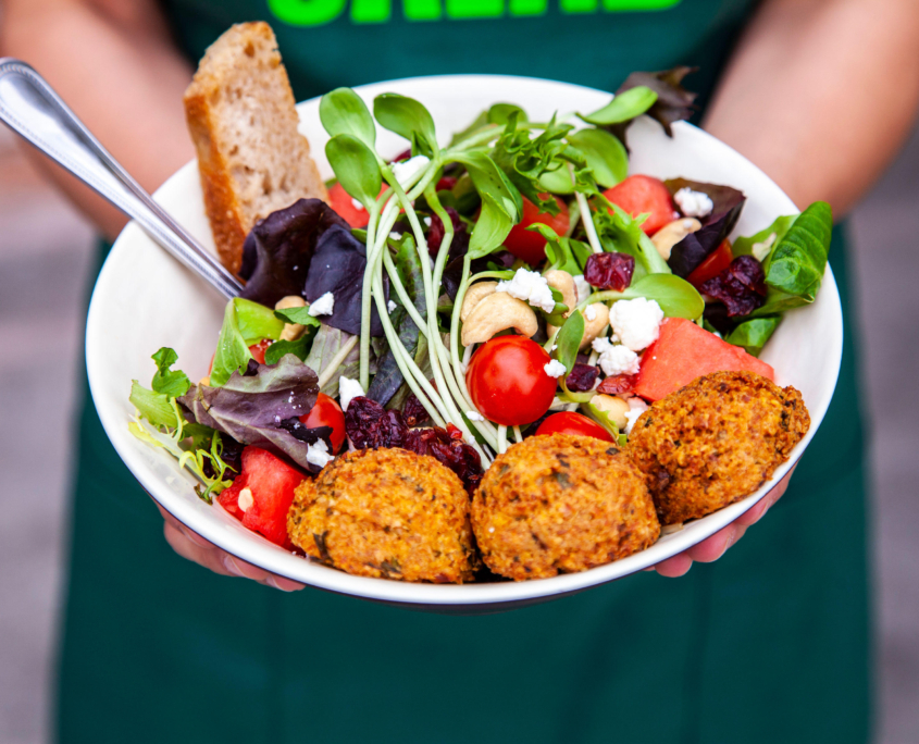 Bowl with a vegetable salad mix of sprouts, purple lettuce, nuts and cranberries