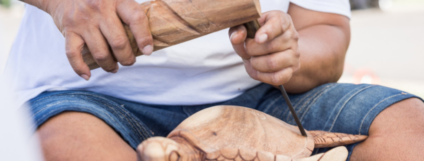 Carving a wooden turtle or honu out of wood at the art show at the Lahaina Cannery Mall