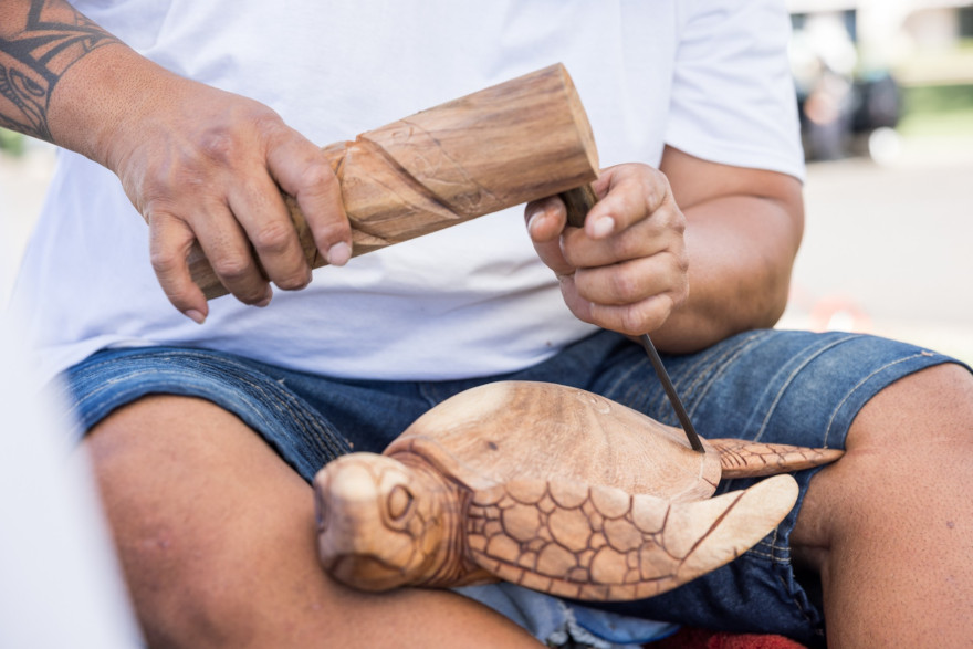 Carving a wooden turtle or honu out of wood at the art show at the Lahaina Cannery Mall