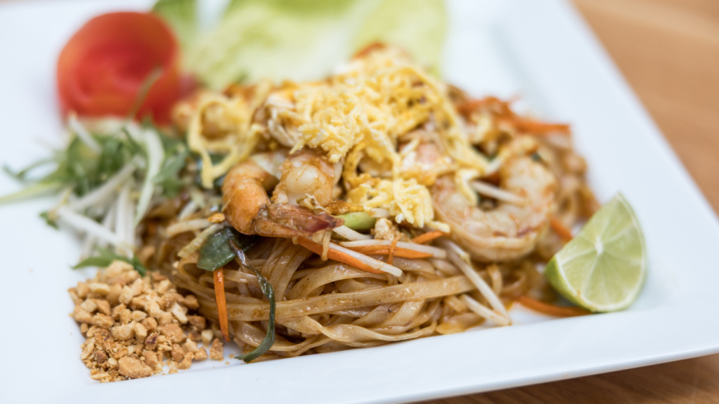 Lahaina Thai Ono Pad Thai noodles with a side of lime and peanuts and a shaved tomato shapped like a flower