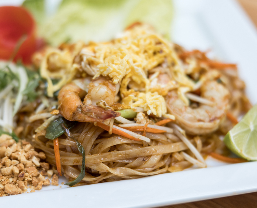 Lahaina Thai Ono Pad Thai noodles with a side of lime and peanuts and a shaved tomato shapped like a flower
